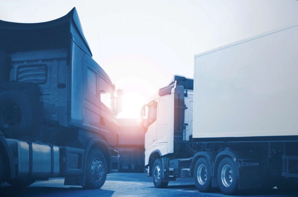 Contabilidade para transportadoras - Um caminhão e um caminhão branco no pátio de uma transportadora